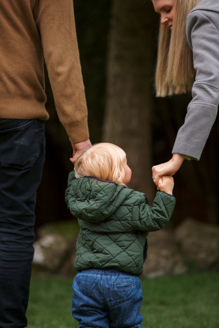 Parents tenant la main de leur enfant, symbole des enjeux familiaux liés à la pension alimentaire