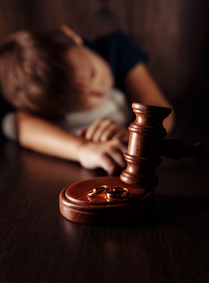 Enfant en arrière-plan et objets juridiques symbolisant le rôle d’un avocat séparation dans les décisions familiales